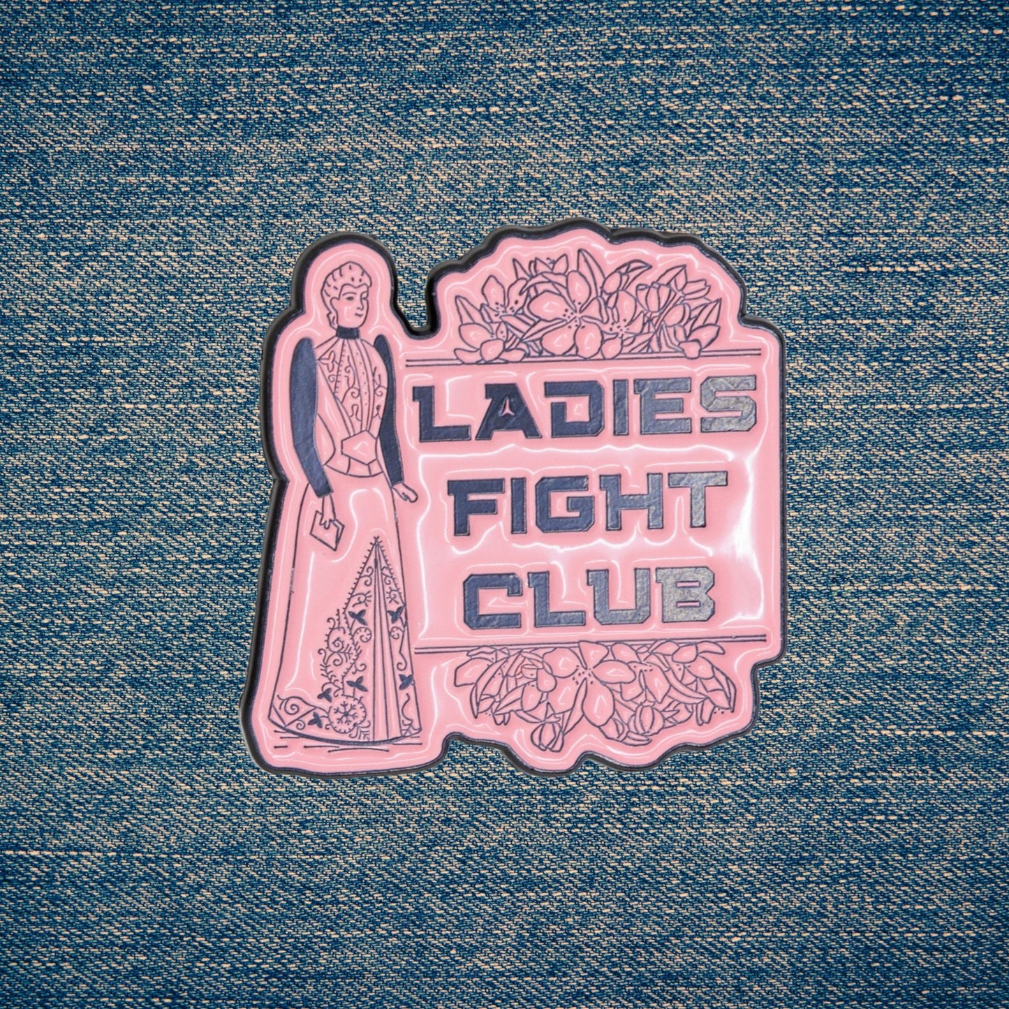Pink 'Ladies Fight Club' pin on denim fabric