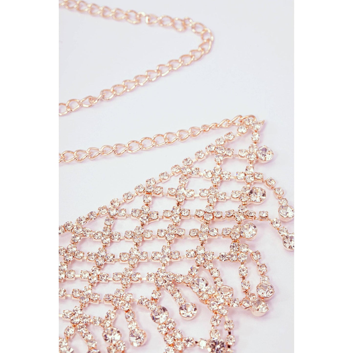 Rose gold chain with crystals on a light pink background