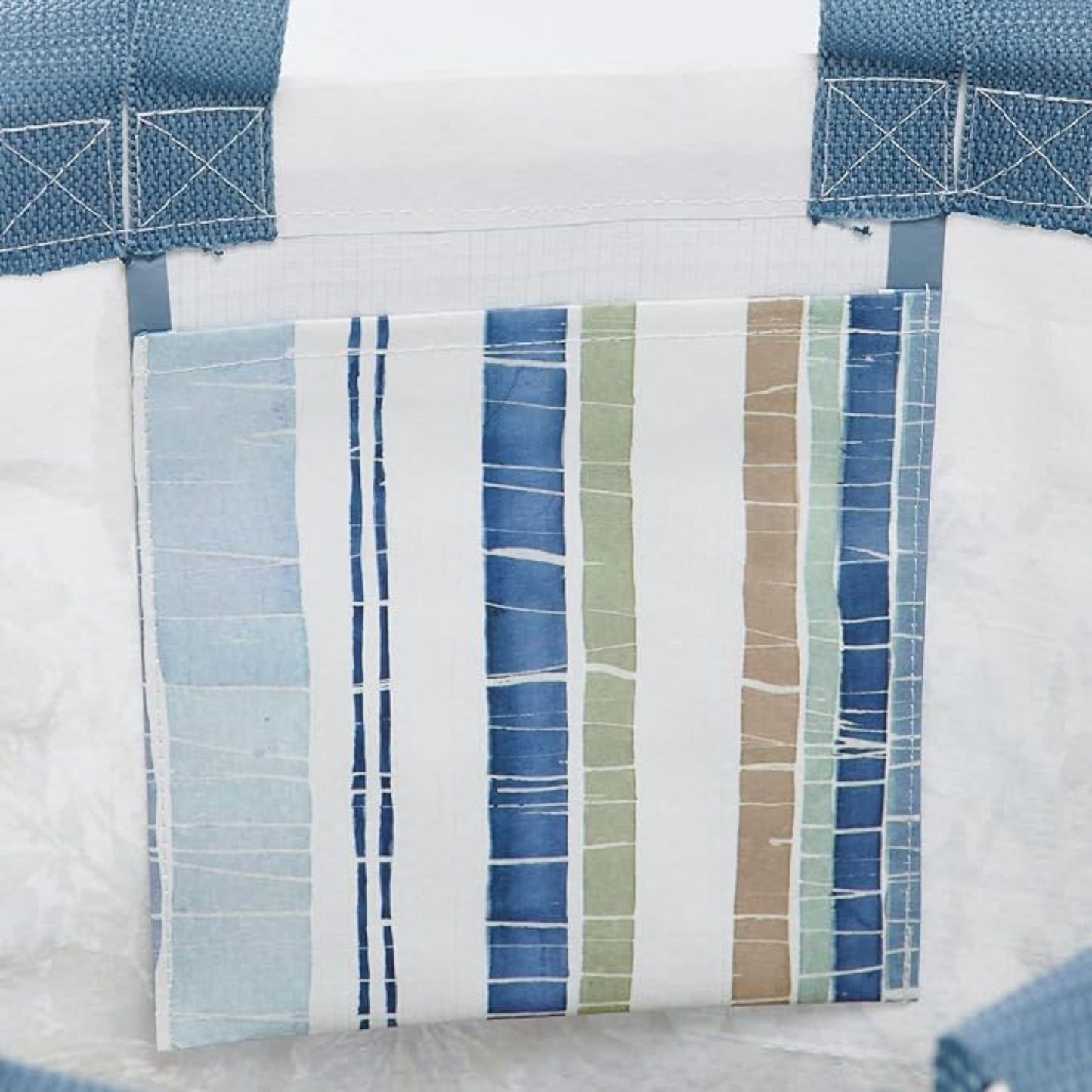 Close-up of an inside pocket of a tote bag with blue and green striped patterns