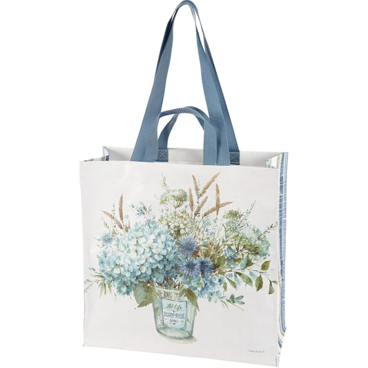 Tote bag with floral design and blue handles on a white background