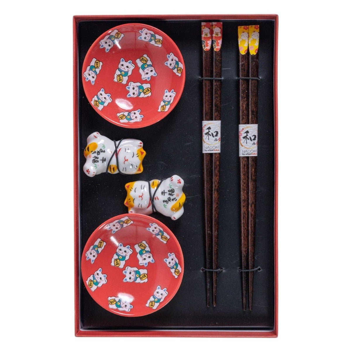Set of red ceramic sauce dish with cat designs, chopsticks, and small decorative items in a box.