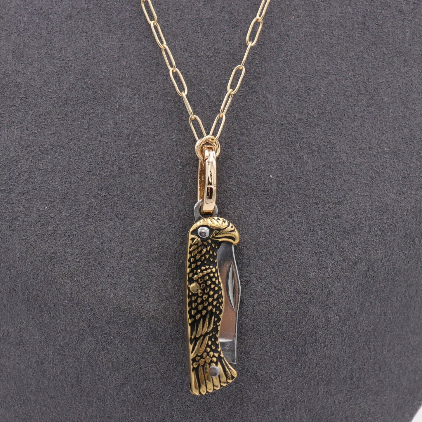 Gold and silver eagle-shaped knife pendant on a chain necklace