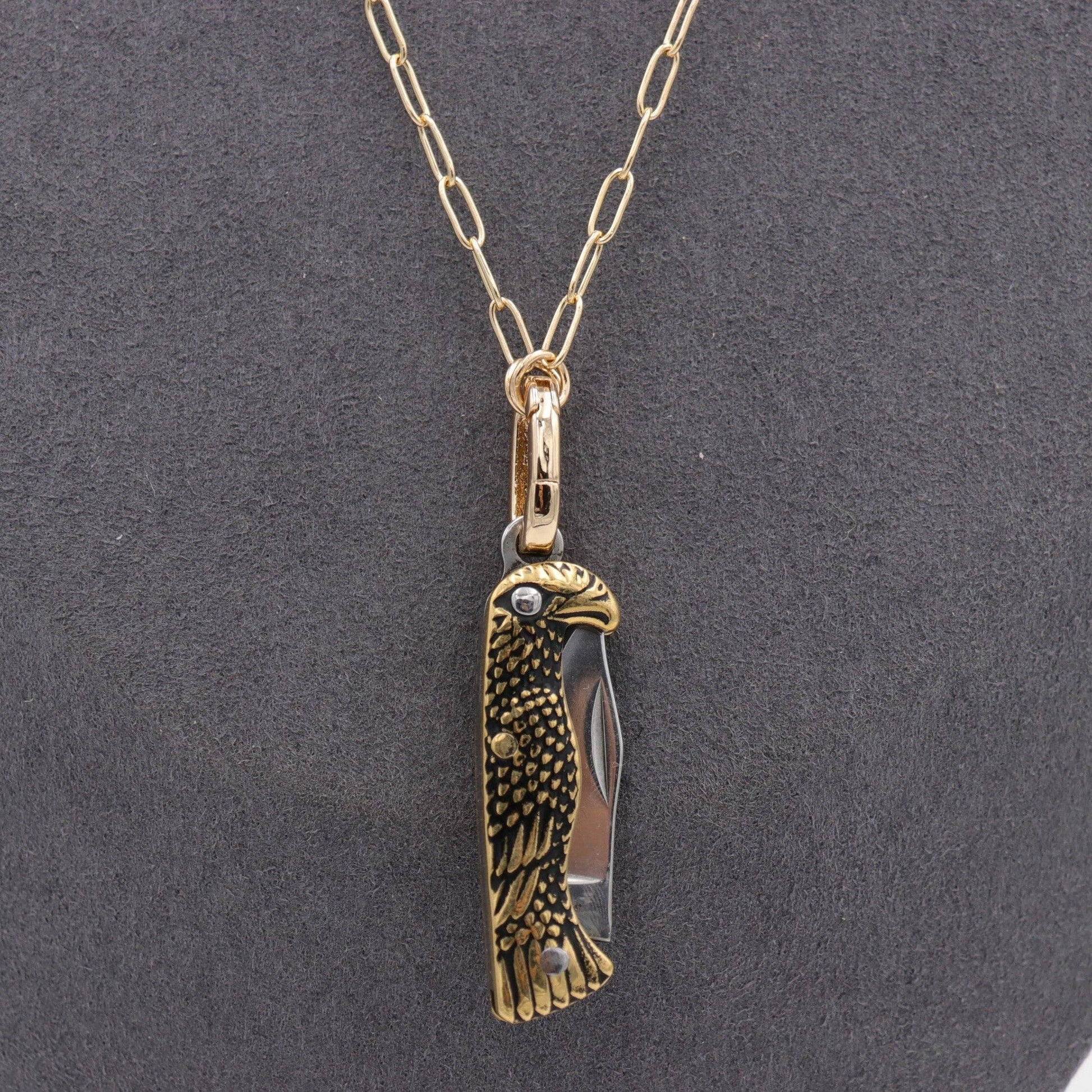 Gold and silver eagle-shaped knife pendant on a chain necklace