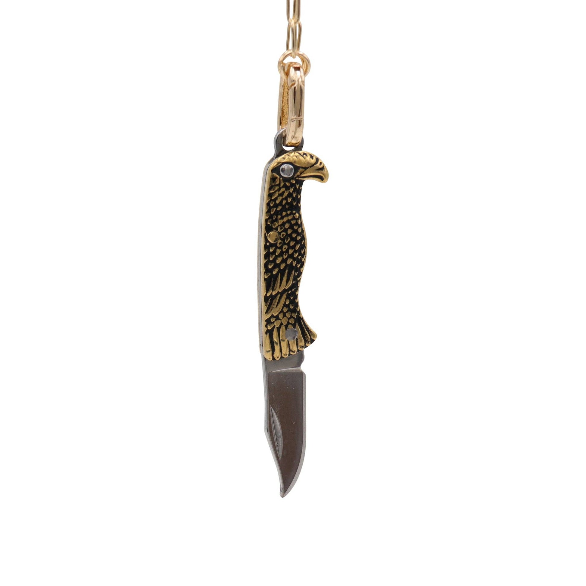 Gold and black eagle-shaped knife pendant on a white background