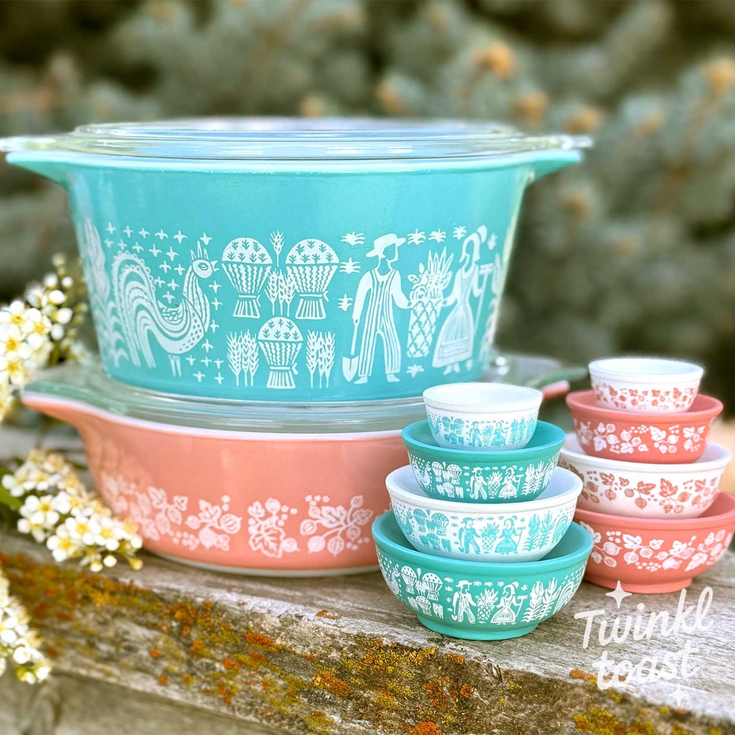 Stacked vintage-style pyrex dishes with floral patterns on a wooden surface.