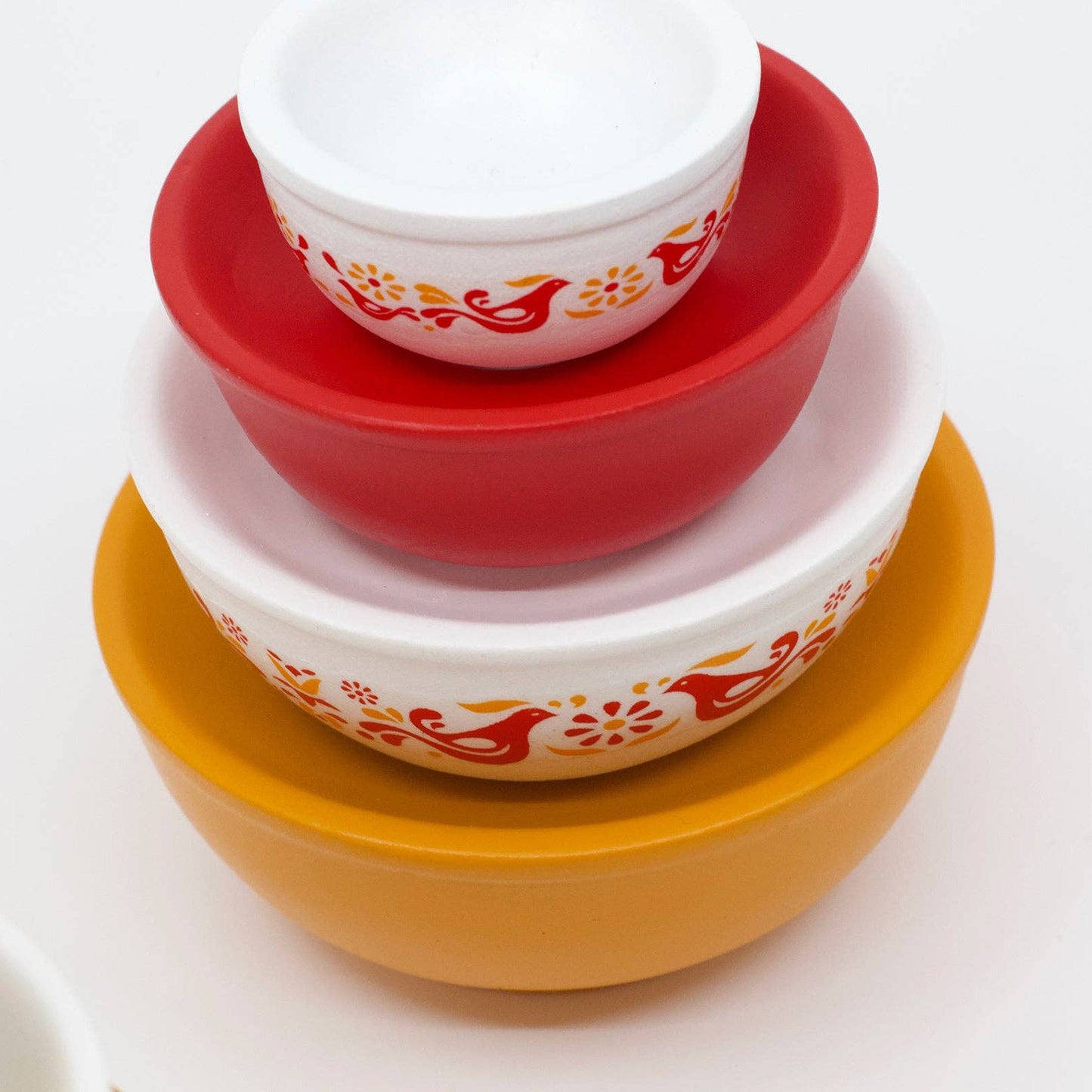 Stack of ceramic bowls with floral patterns on a white background
