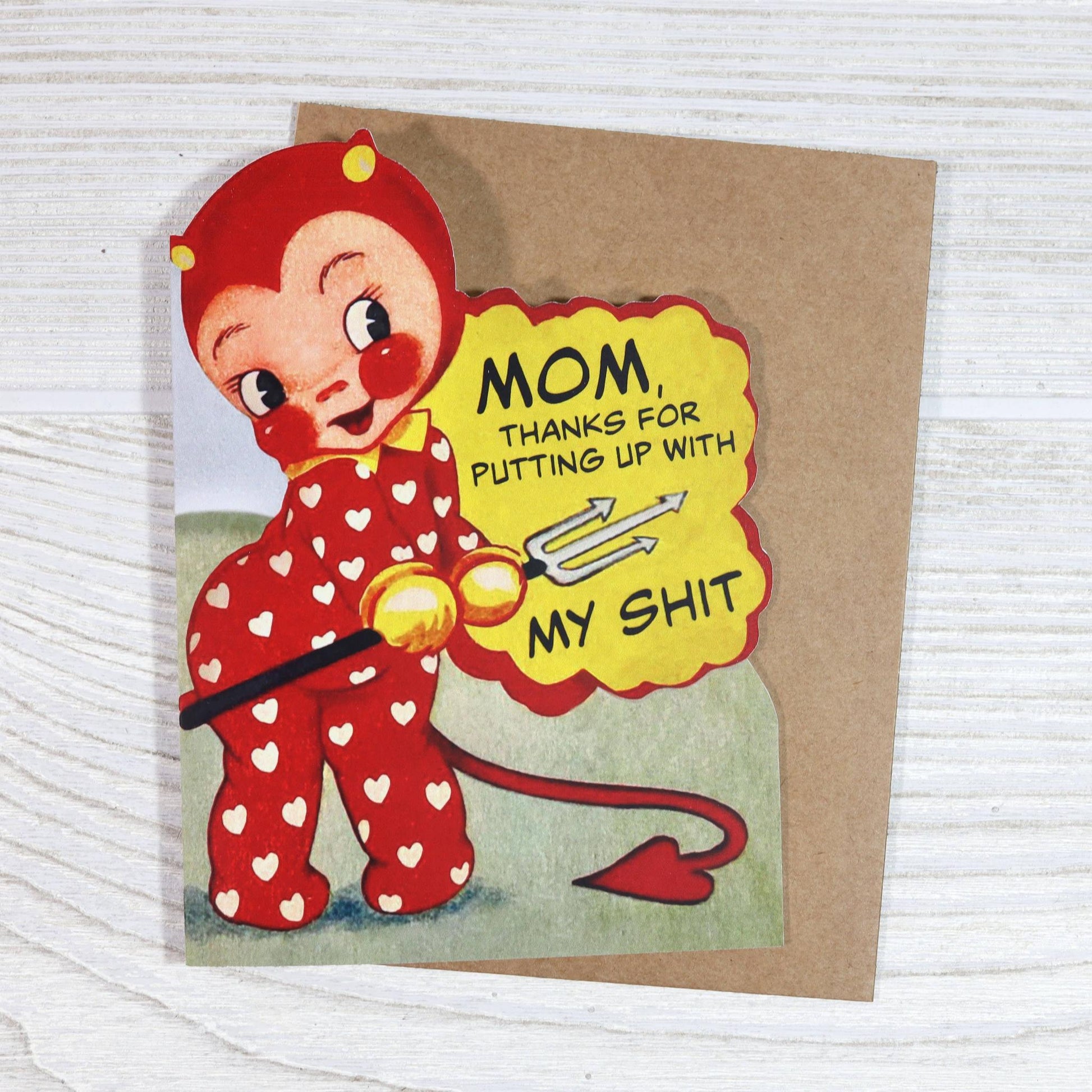 Card with a cartoon character in a red outfit with hearts and a yellow sign saying 'Mom, thanks for putting up with my shit'.