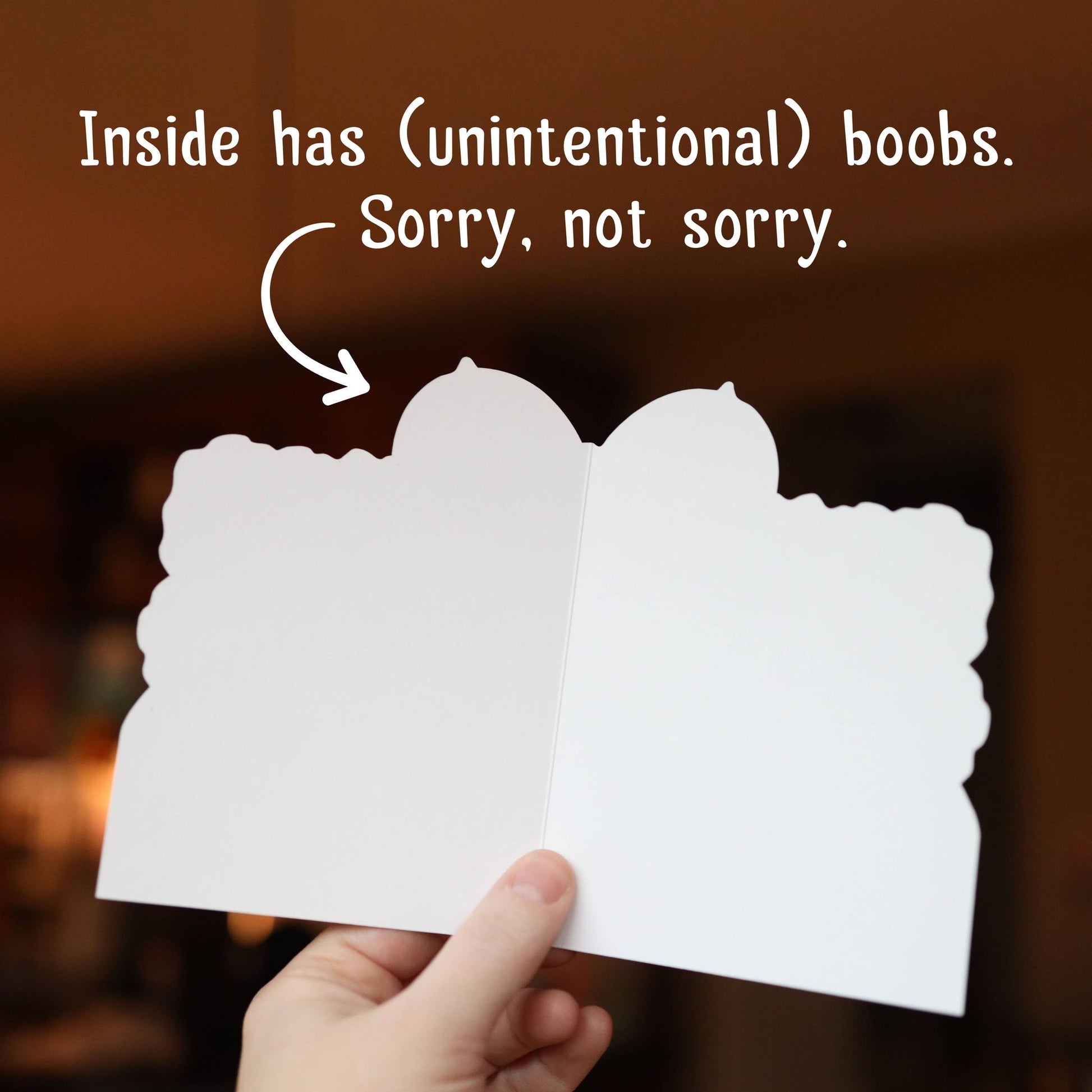 Open blank card, held by a hand against a blurred background.
