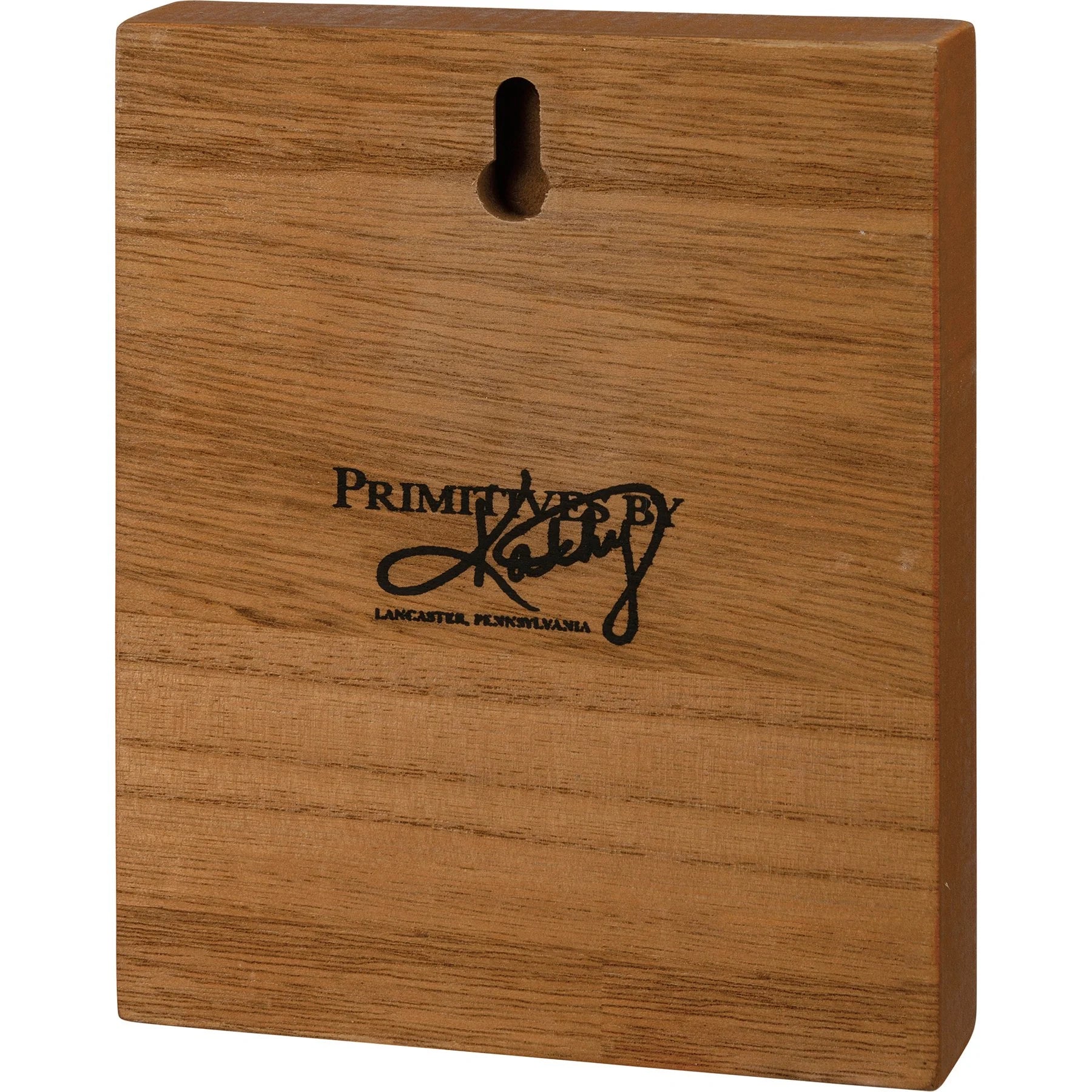 Wooden block with 'Primitives by Kathy' logo on a white background