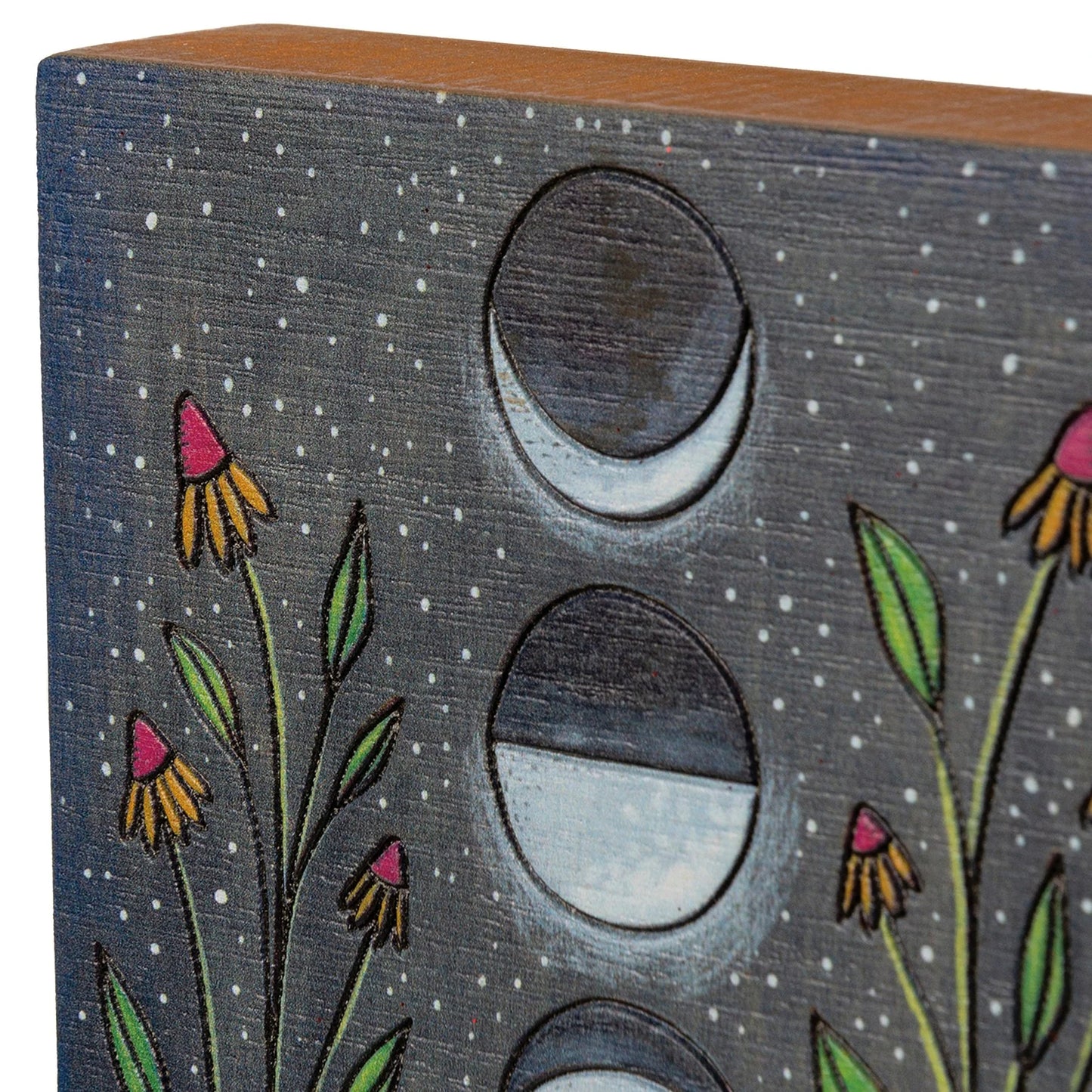 Wooden block with moon phases and flowers on a dark background