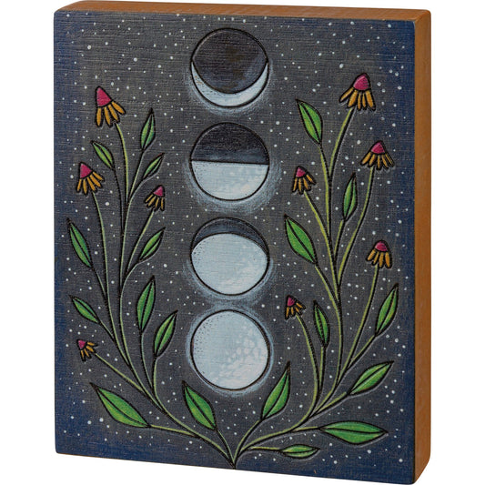Wooden block with moon phases and floral design on a starry night background