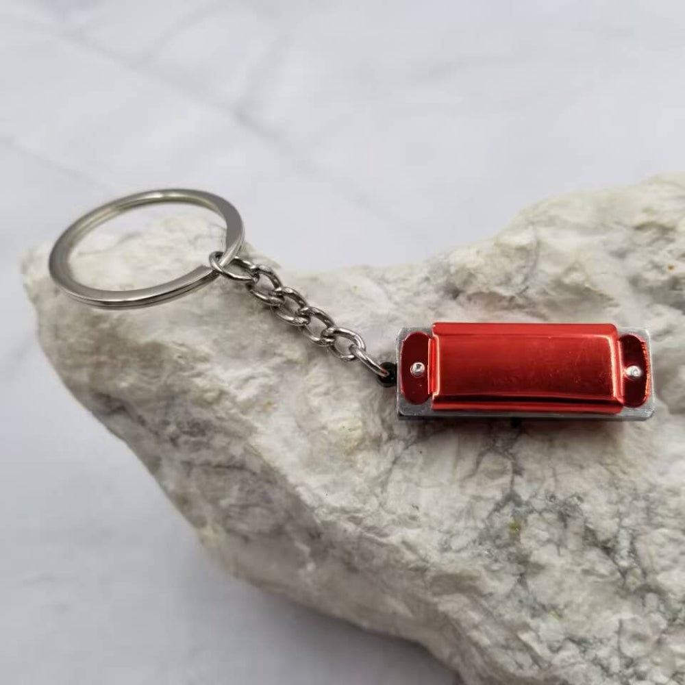 Red harmonica keychain on a rock