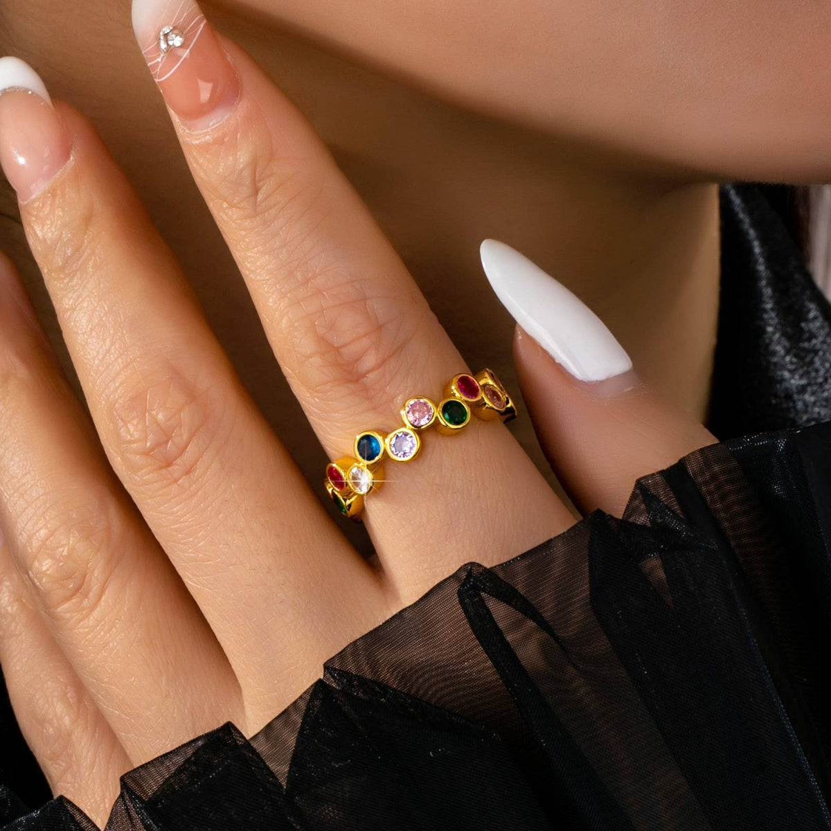Close-up of a hand wearing a colorful gemstone ring