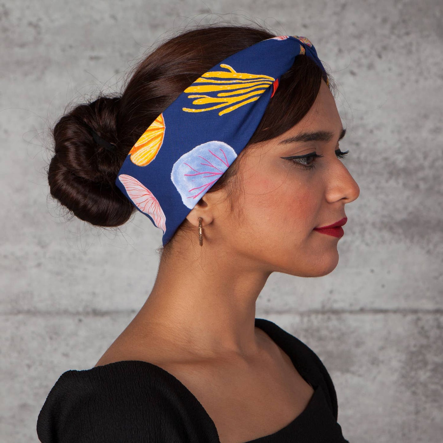 Woman wearing a colorful bandana with coral designs