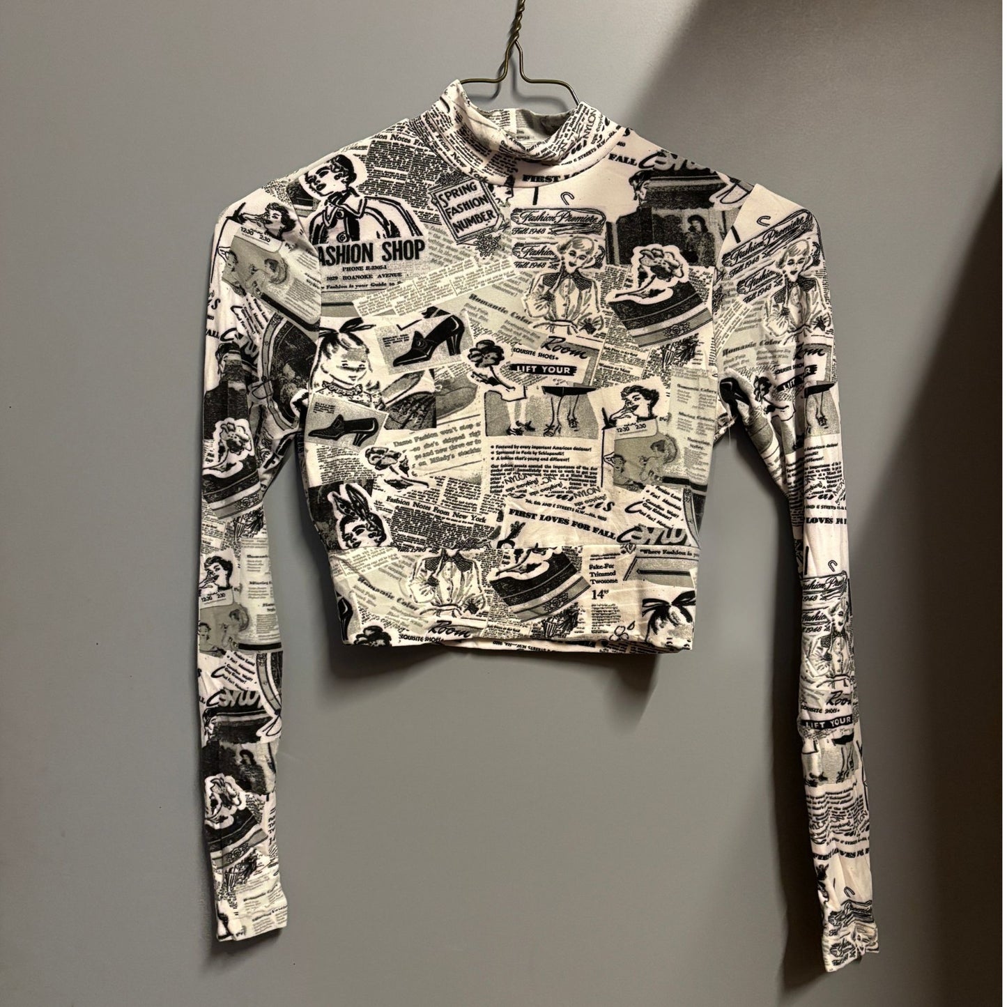 Black and white patterned long-sleeve shirt on a hanger against a gray background