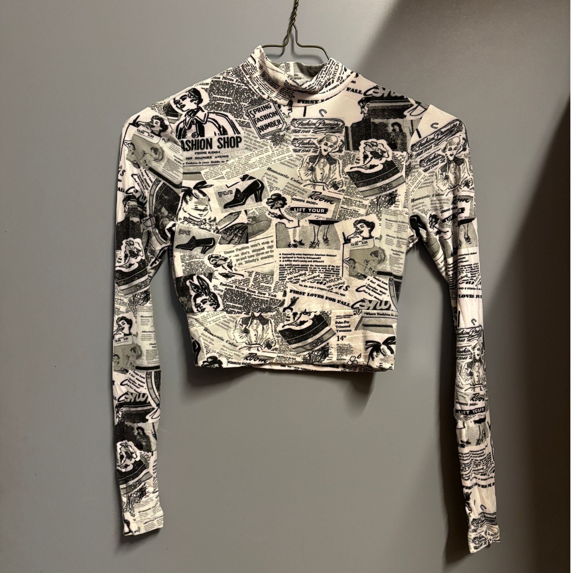 Black and white patterned long-sleeve shirt on a hanger against a gray background