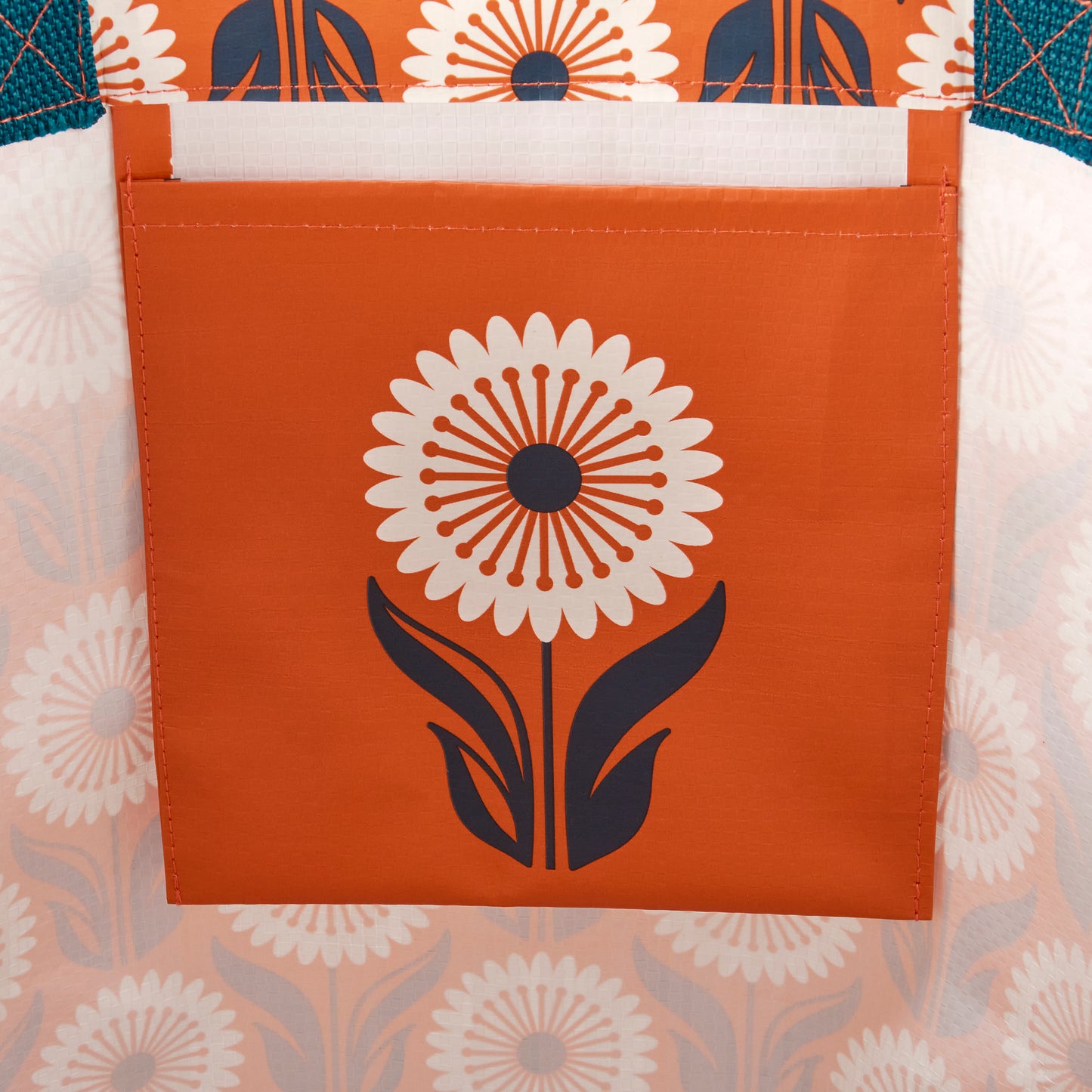 Inside of a tote bag with floral-patterned fabric and a central flower design on an orange background