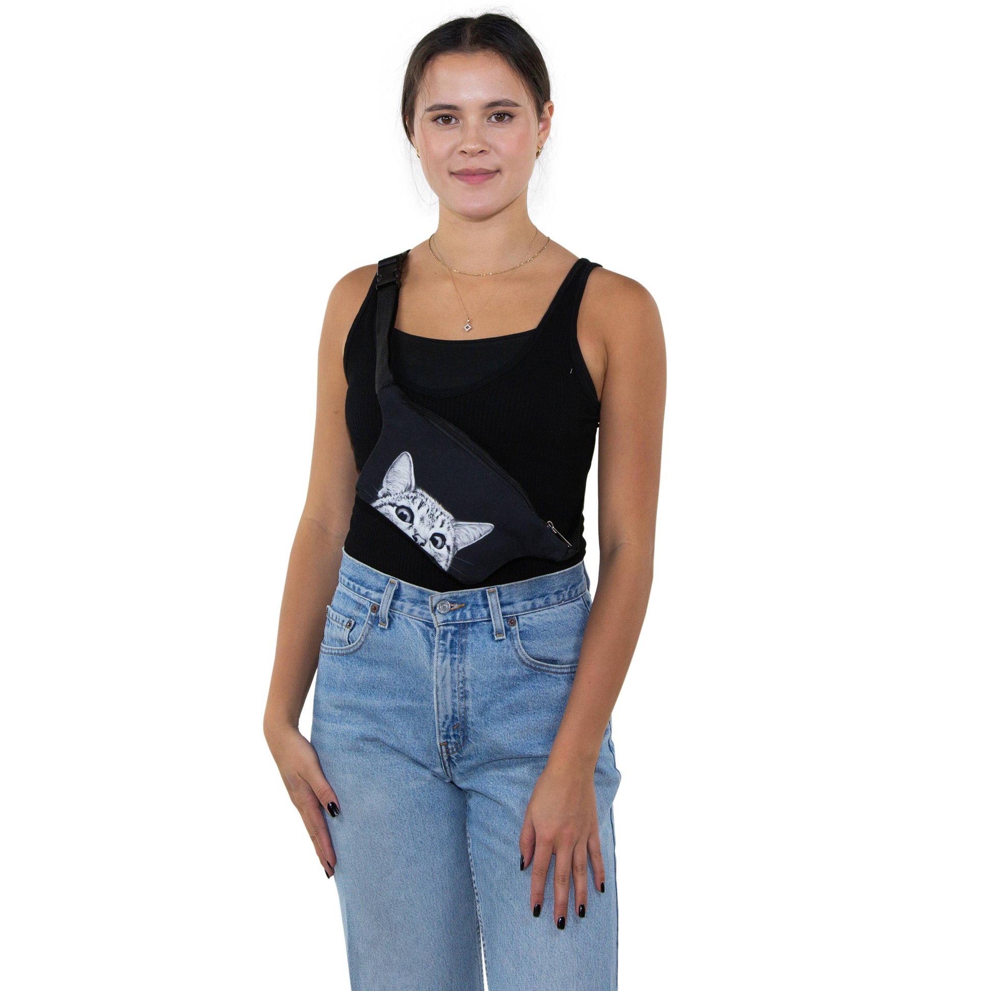 Woman wearing a black tank top with a cat design and blue jeans on a white background