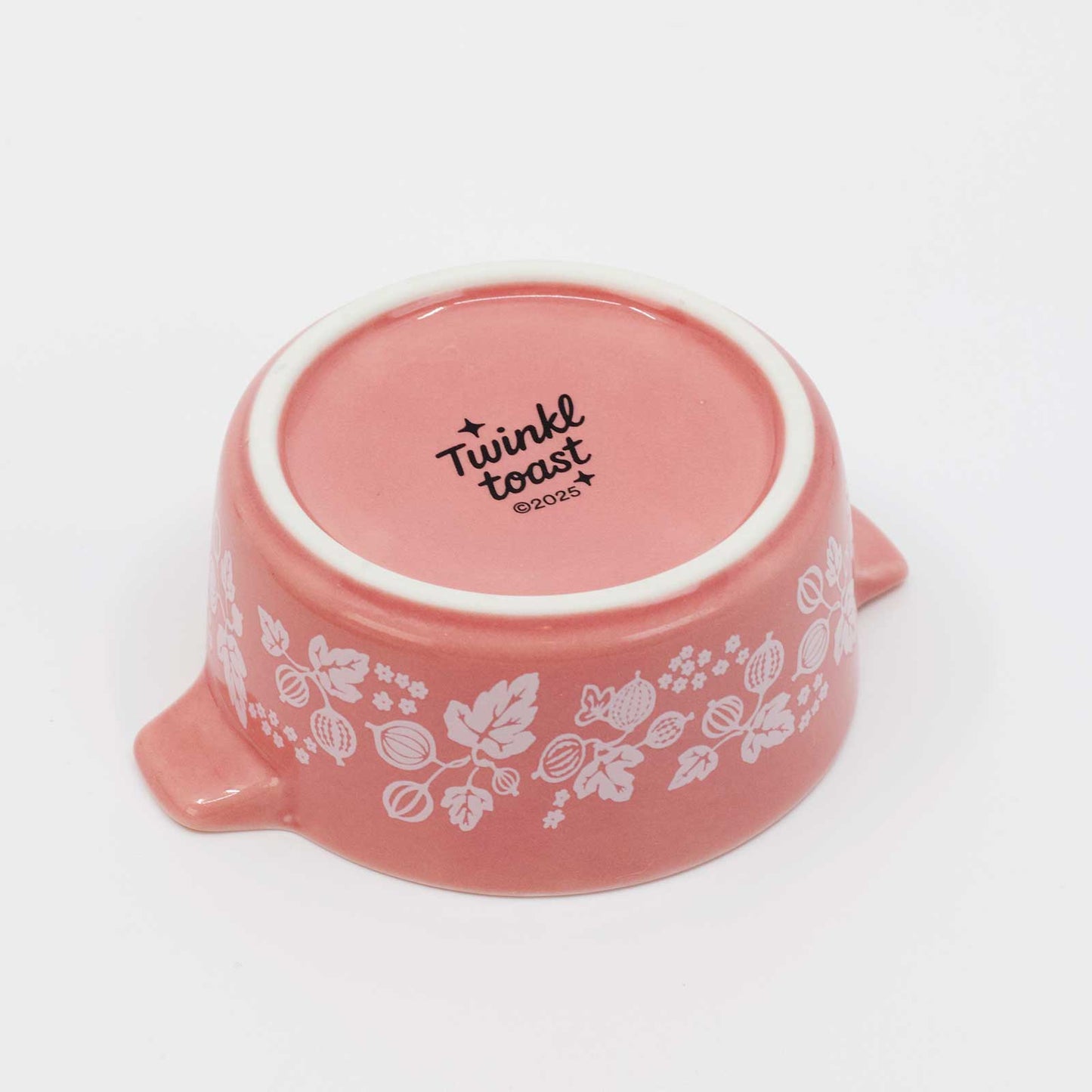 Pink ceramic bowl with floral patterns and 'Twinkl toast' text on a white background