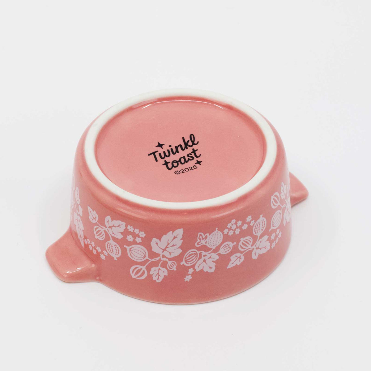 Pink ceramic bowl with floral patterns and 'Twinkl toast' text on a white background