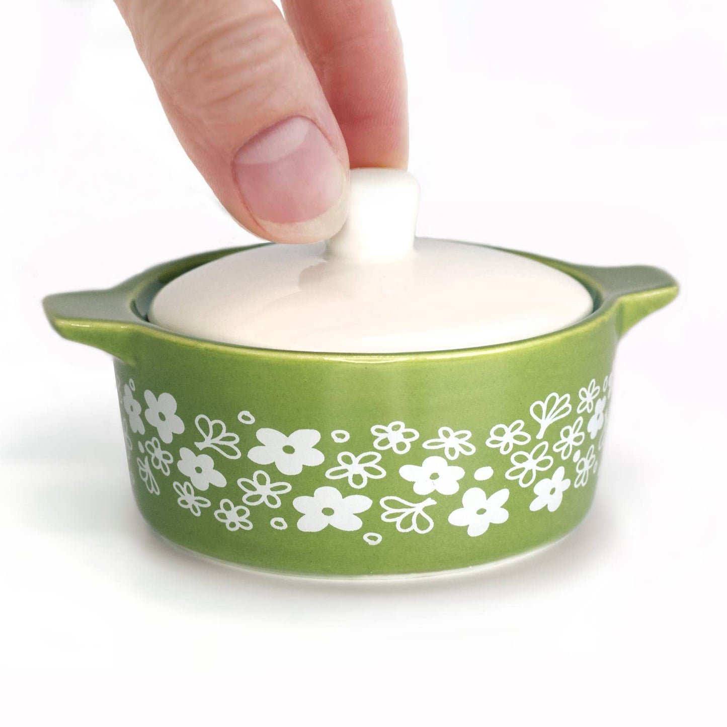 Green Pyrex-inspired container with floral patterns on a white background