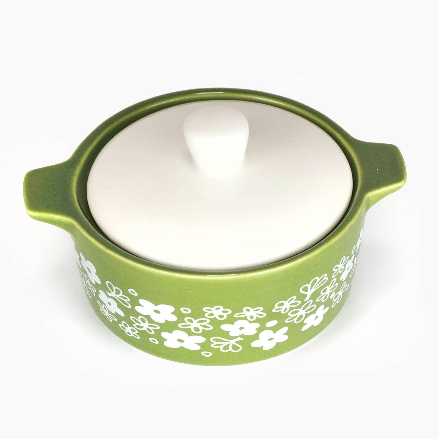 Pyrex-inspired green ceramic dish with white floral patterns on a white background