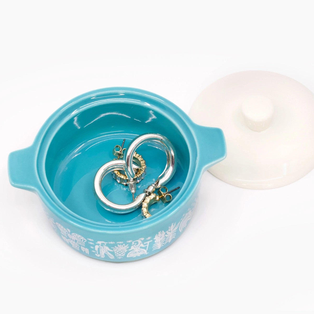 Turquoise jewelry box with gold and silver earrings on a white background
