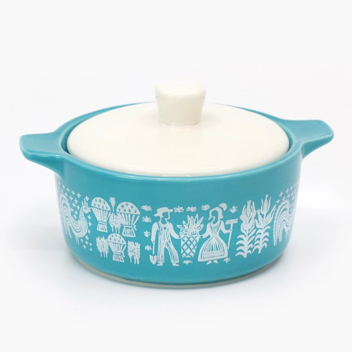 Turquoise ceramic dish with white lid and decorative patterns on a white background