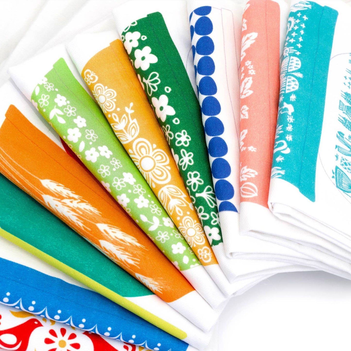 Set of colorful patterned dish towels on a white background