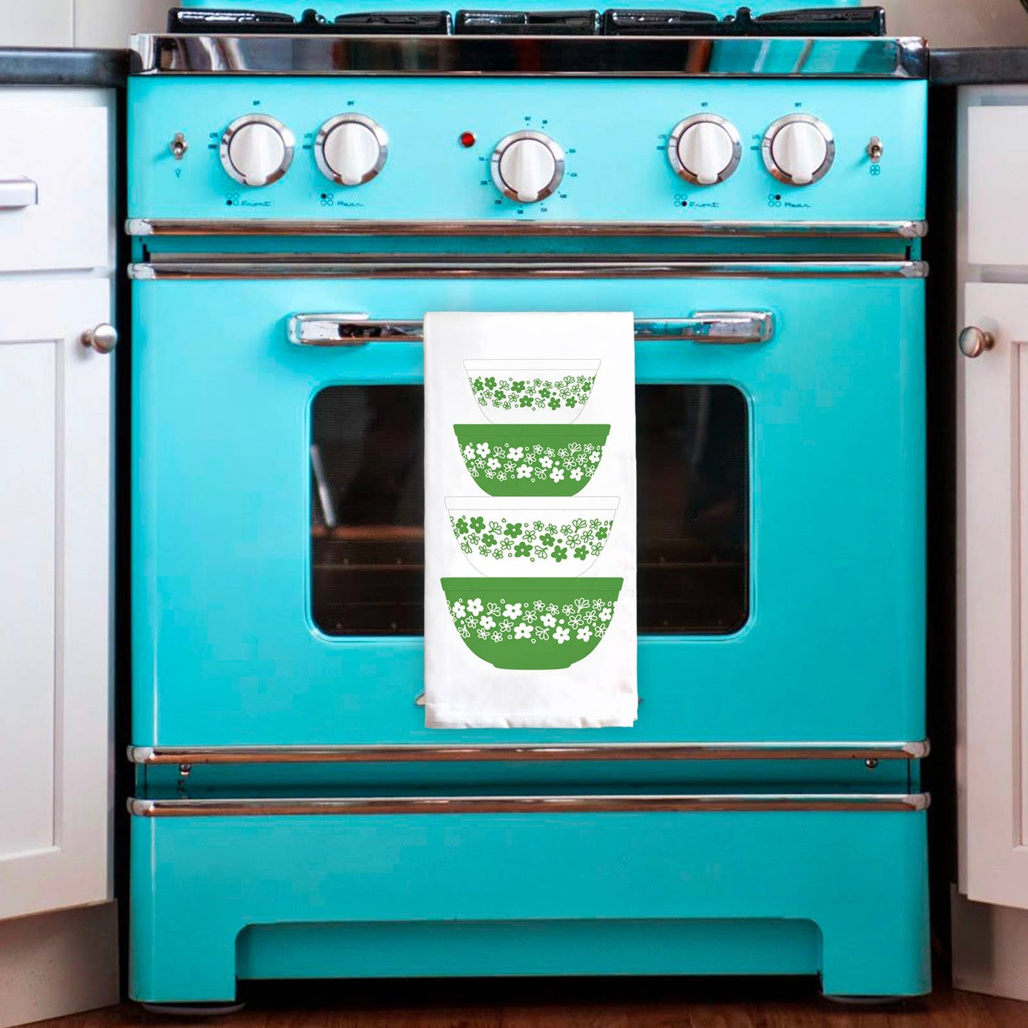 Turquoise oven with a white towel featuring green bowls illustration in a kitchen setting