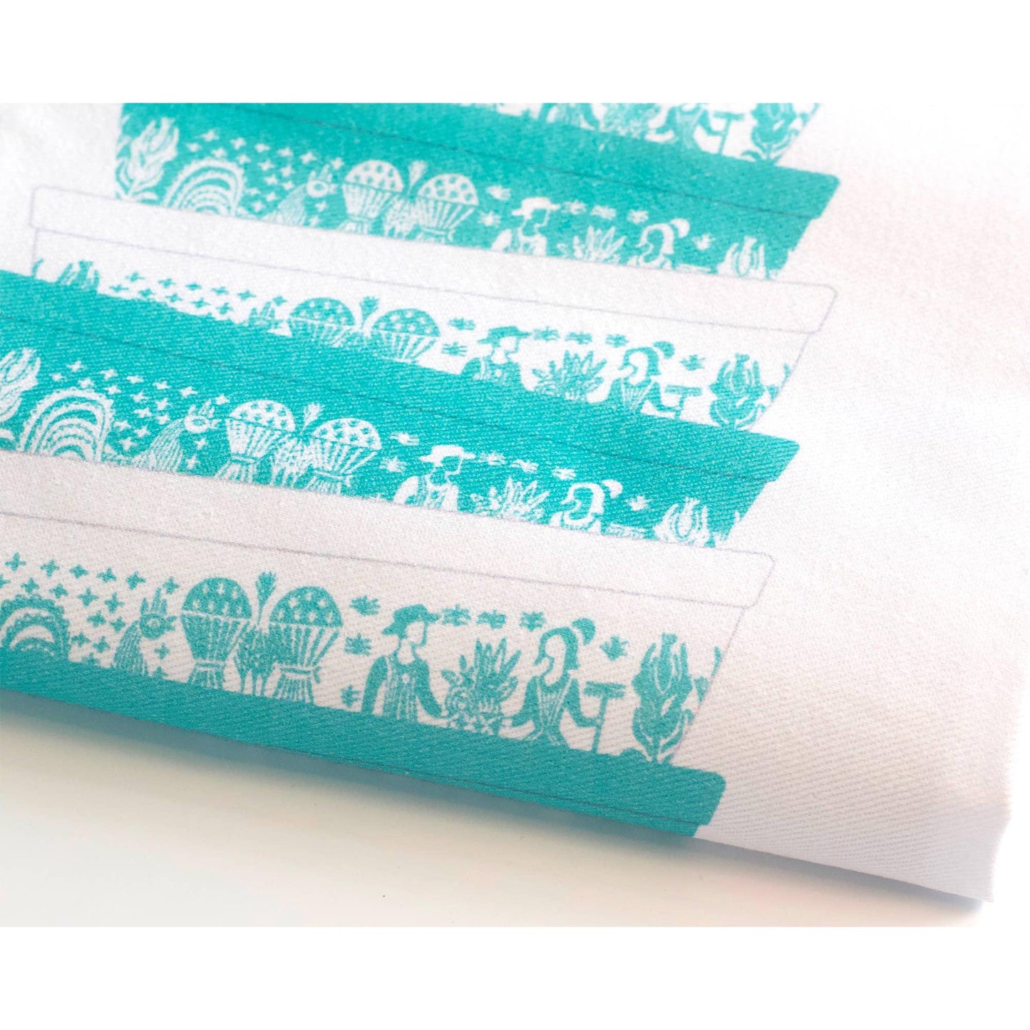 Teal and white patterned dish towel on a light background
