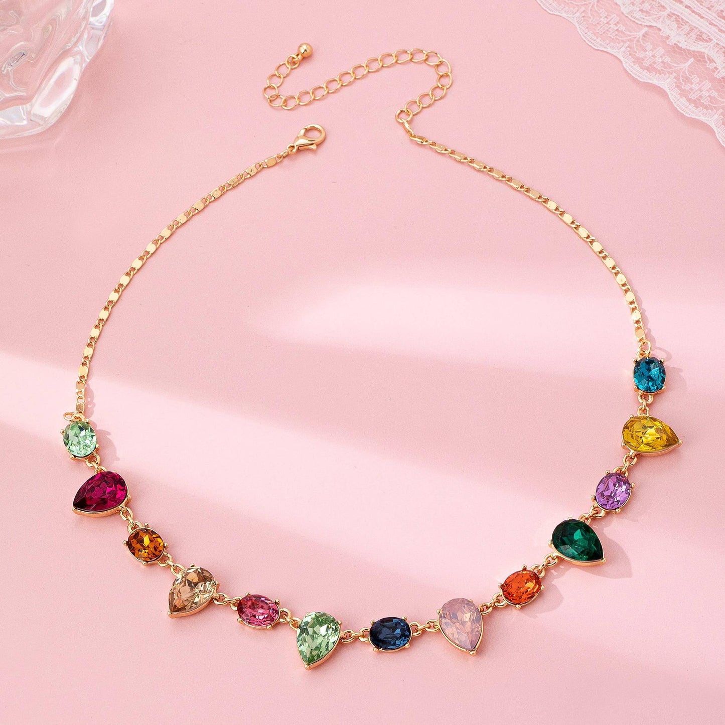 Multicolored gemstone necklace on a pink background