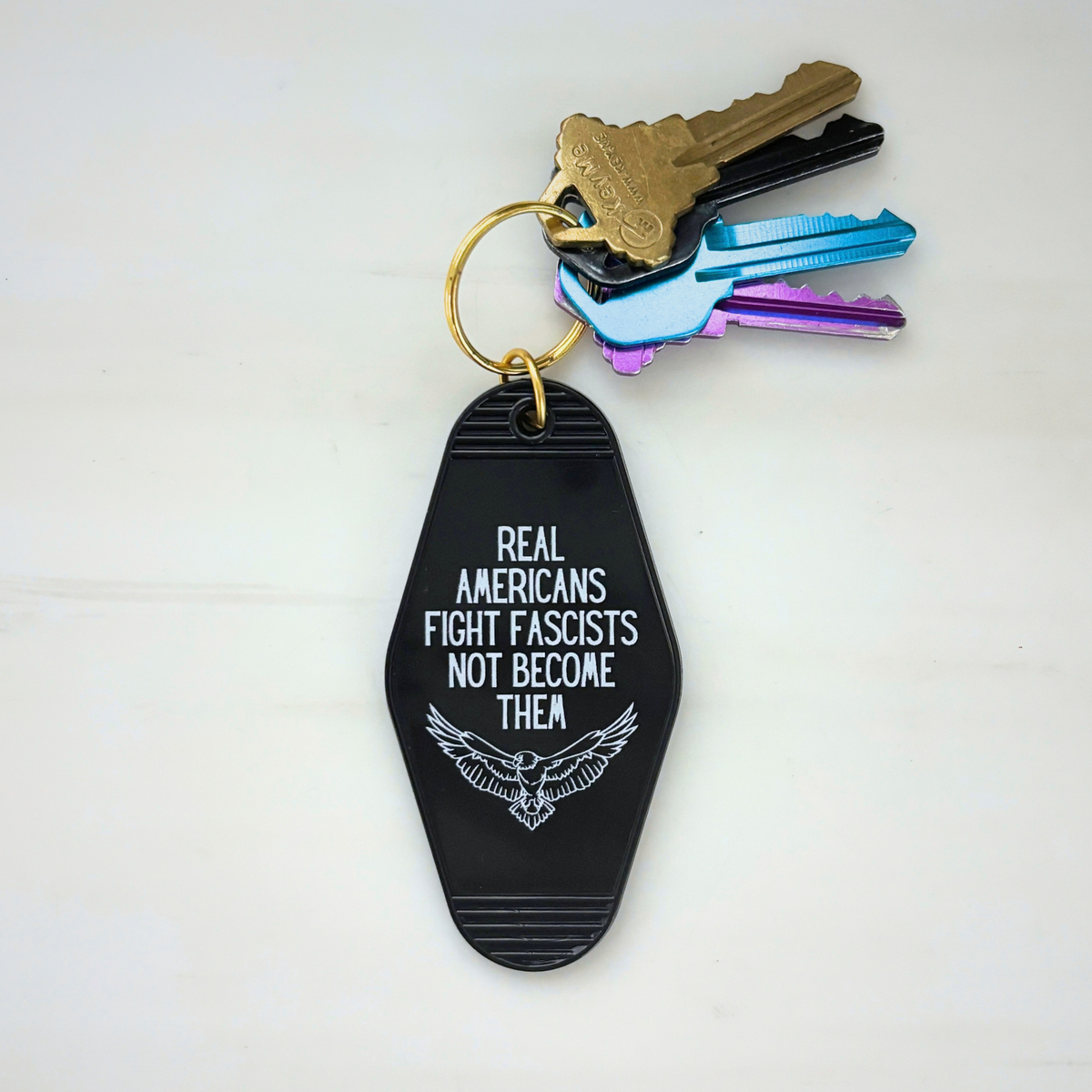 Real Americans Fight Fascists Not Become Them Motel Style Keychain in Black-GetBullish-The Bullish Store