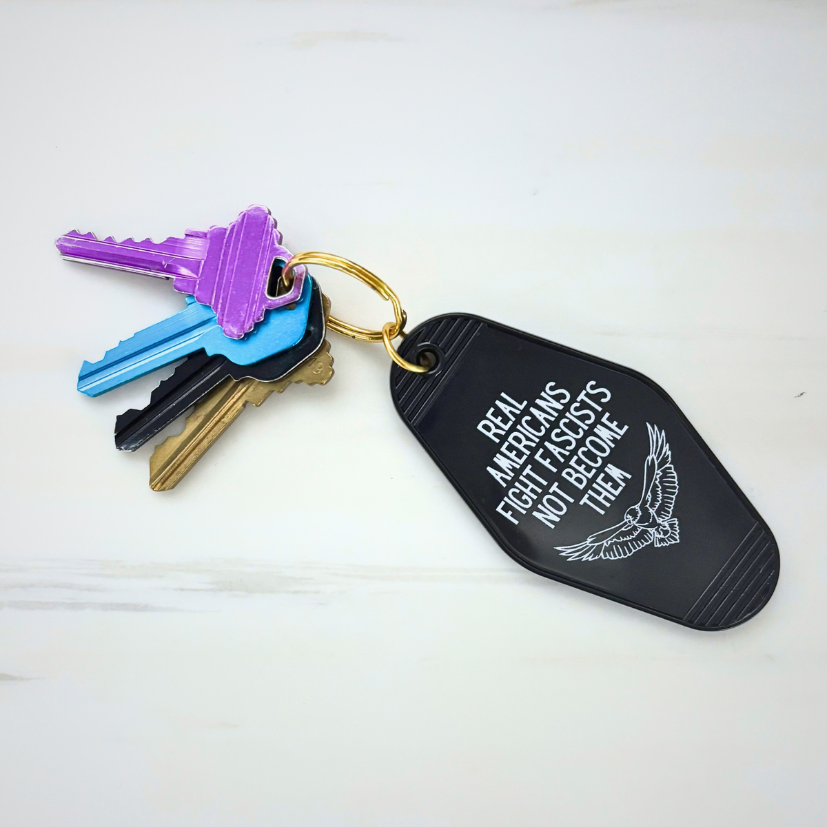 Real Americans Fight Fascists Not Become Them Motel Style Keychain in Black-GetBullish-The Bullish Store