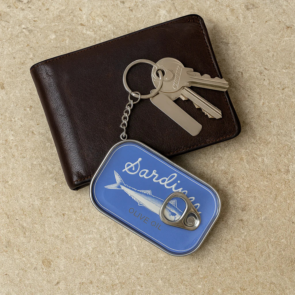 Keychain with sardine can design on a beige surface