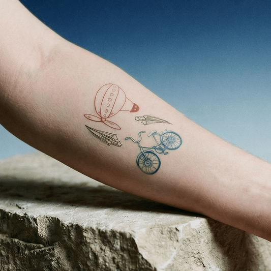 Person's arm with a tattoo on a stone block against a blue sky.