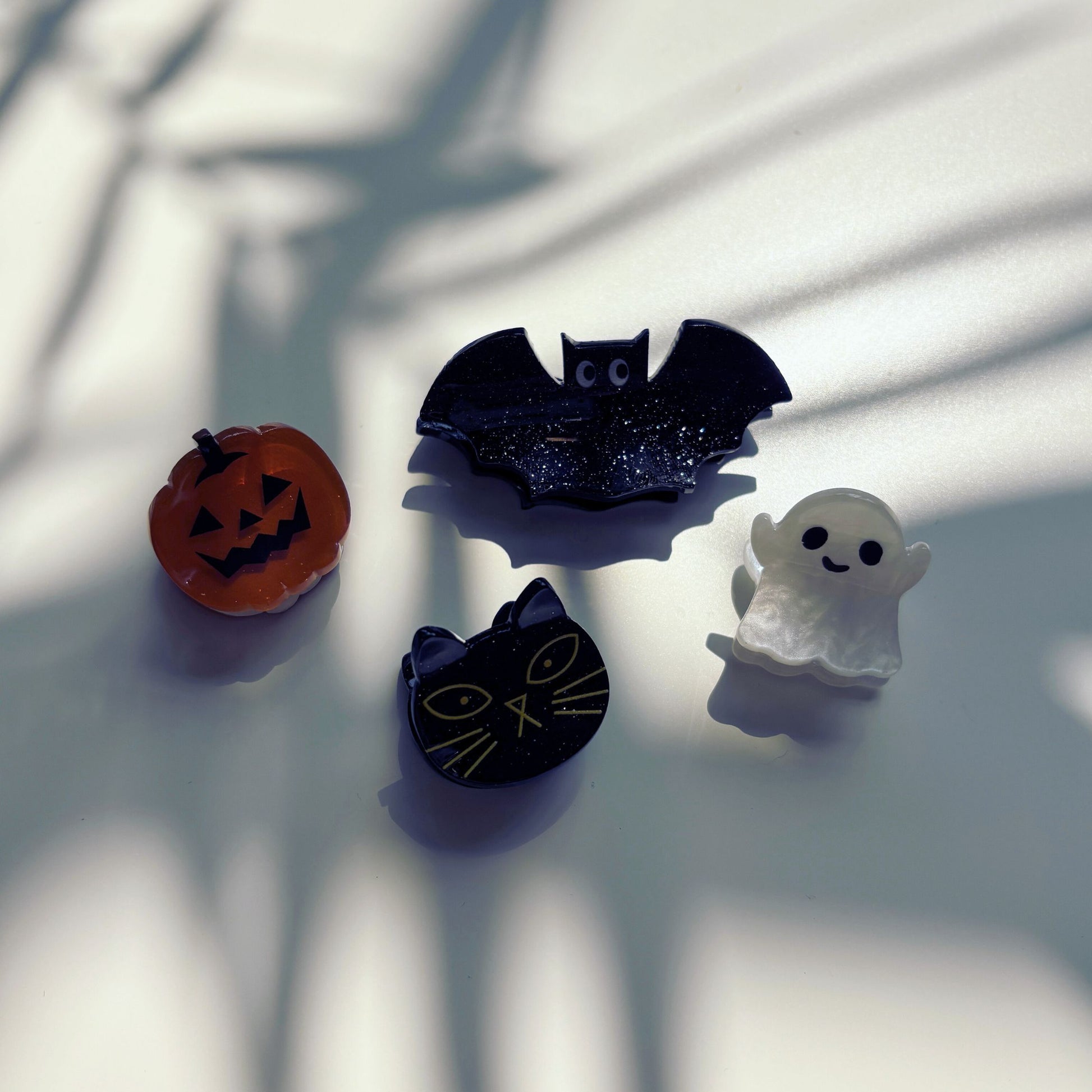 Four Halloween-themed hair clips on a light surface with shadows.