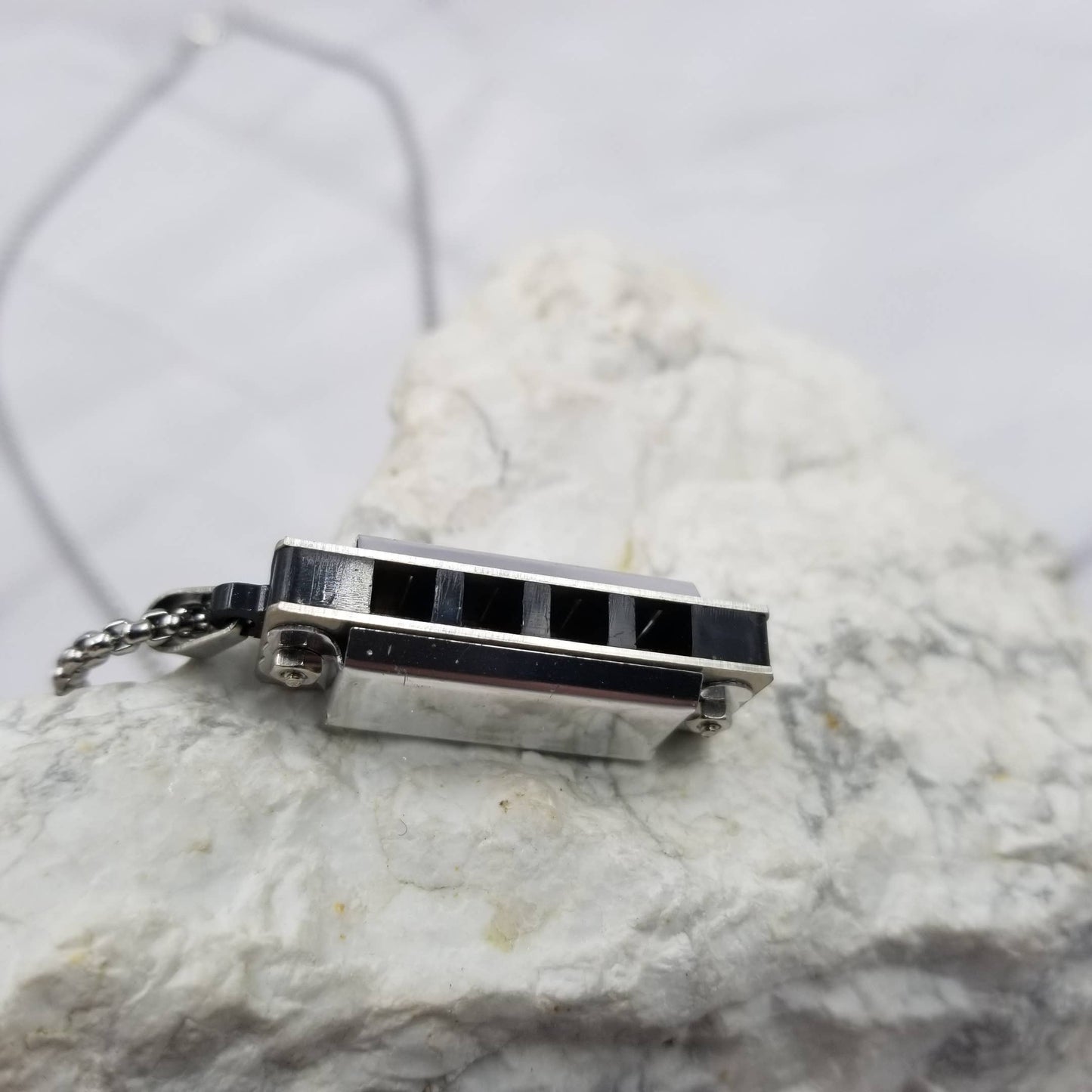 Small rectangular pendant with black accents on a marble surface