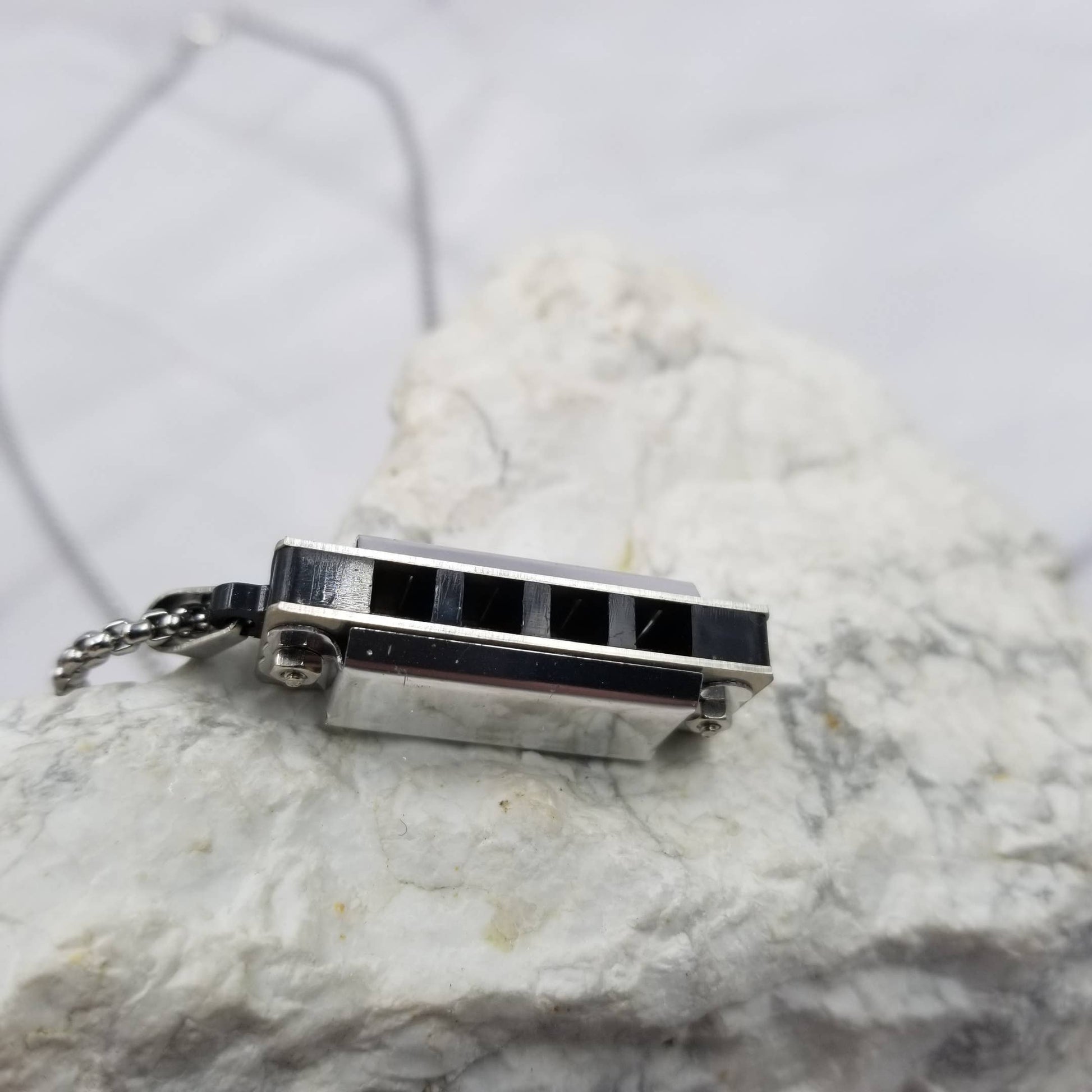 Small rectangular pendant with black accents on a marble surface