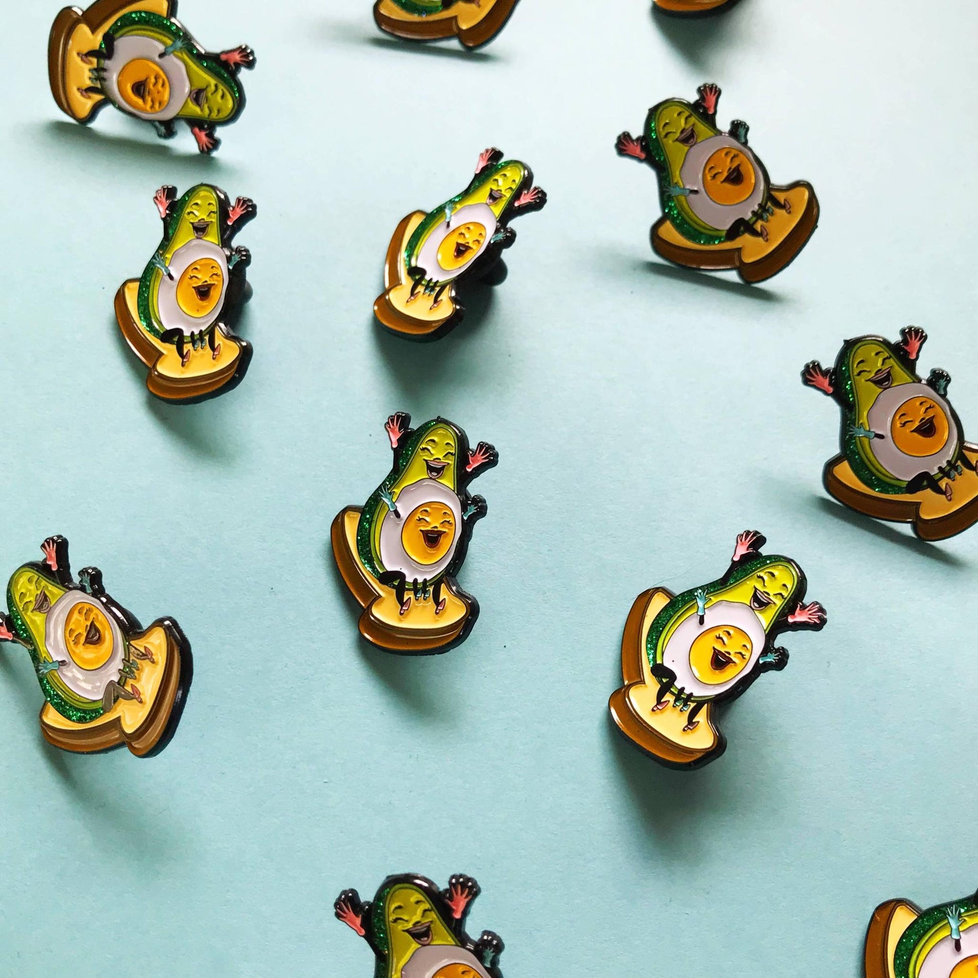 Avocado-themed pins on a light blue background
