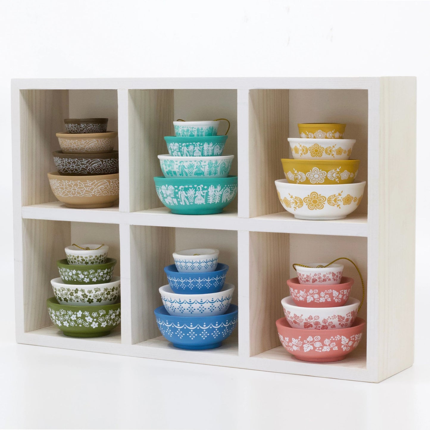 Set of colorful bowls stacked in a wooden shelf unit