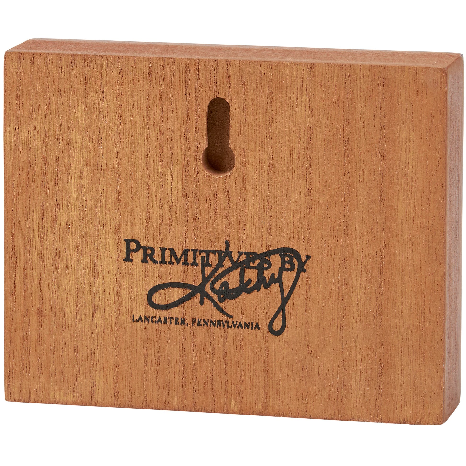 Wooden block with 'Primitives by Kathy' branding on a white background