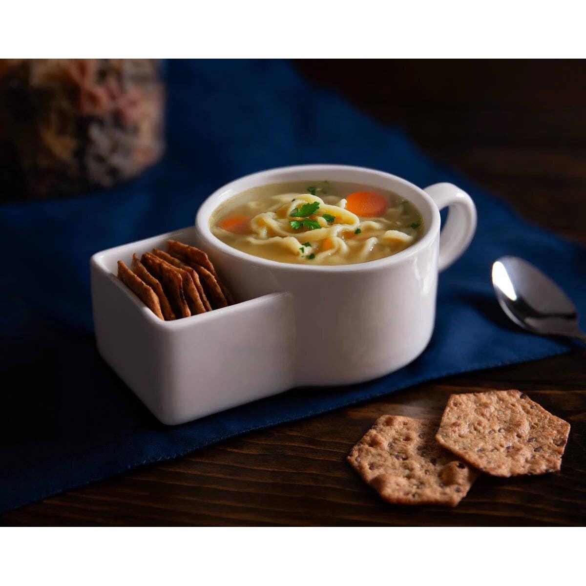 White ceramic bowl with soup and crackers on a blue napkin