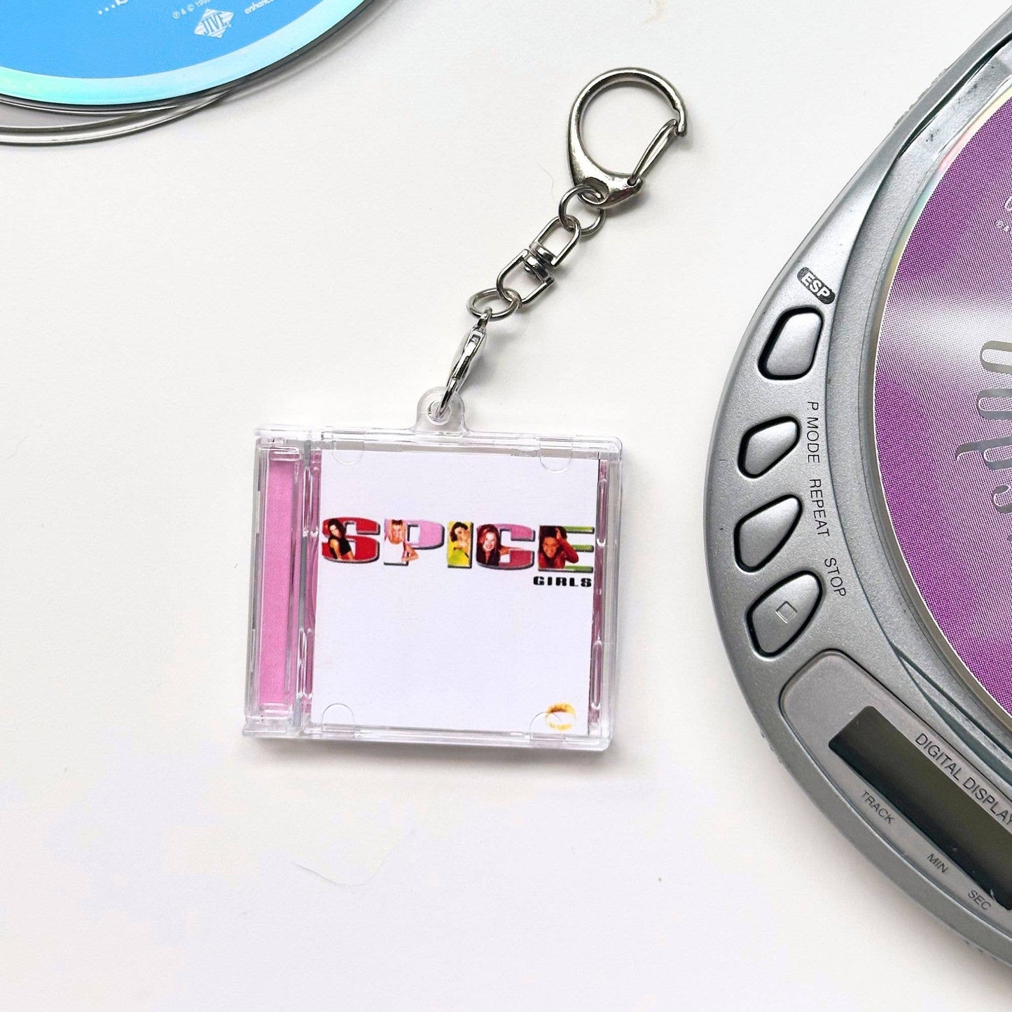 Spice Girls CD case shaped keychain  next to a digital music player