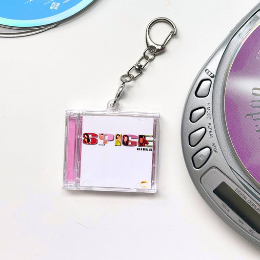 Spice Girls CD case shaped keychain  next to a digital music player