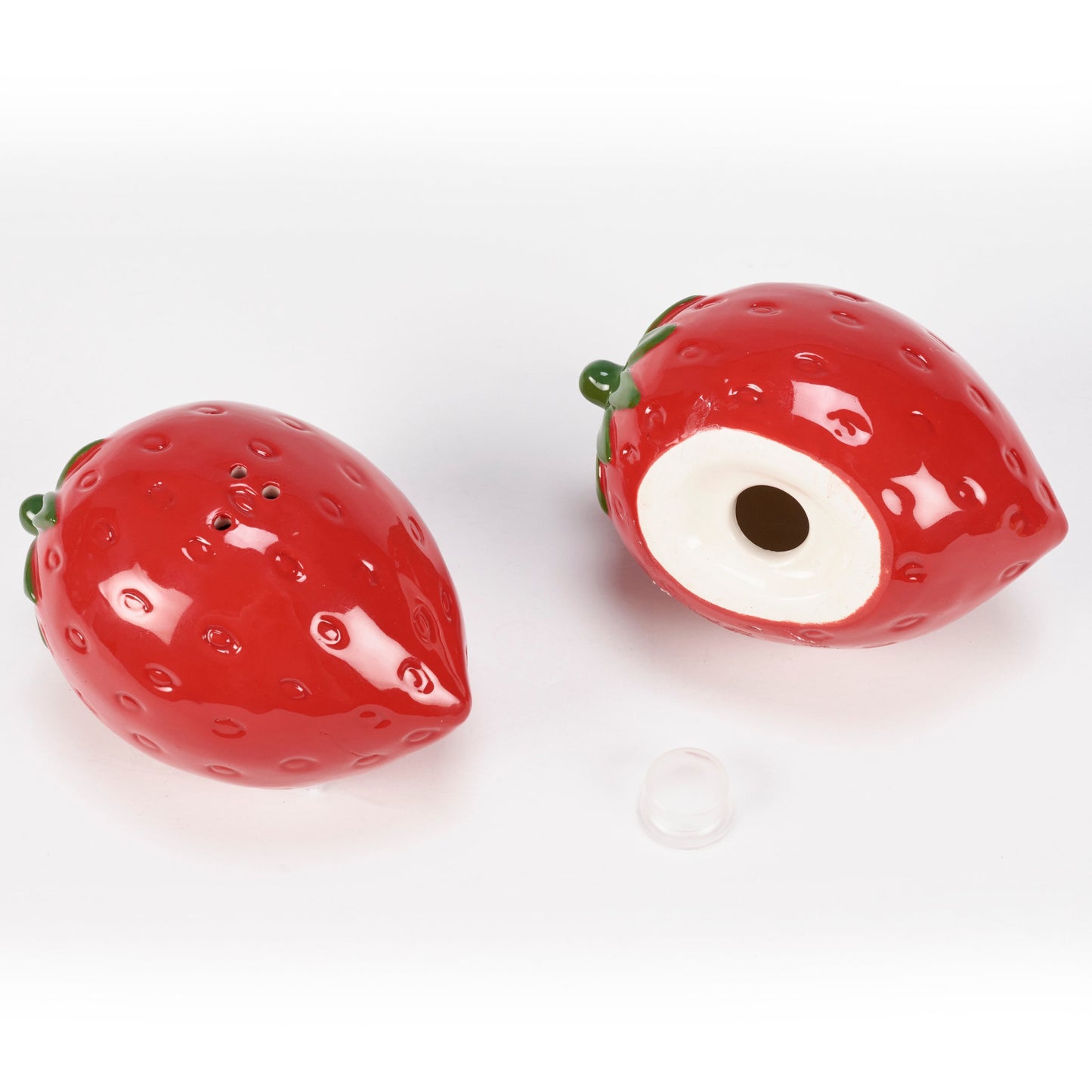 Two strawberry-shaped salt and pepper shakers on a white background