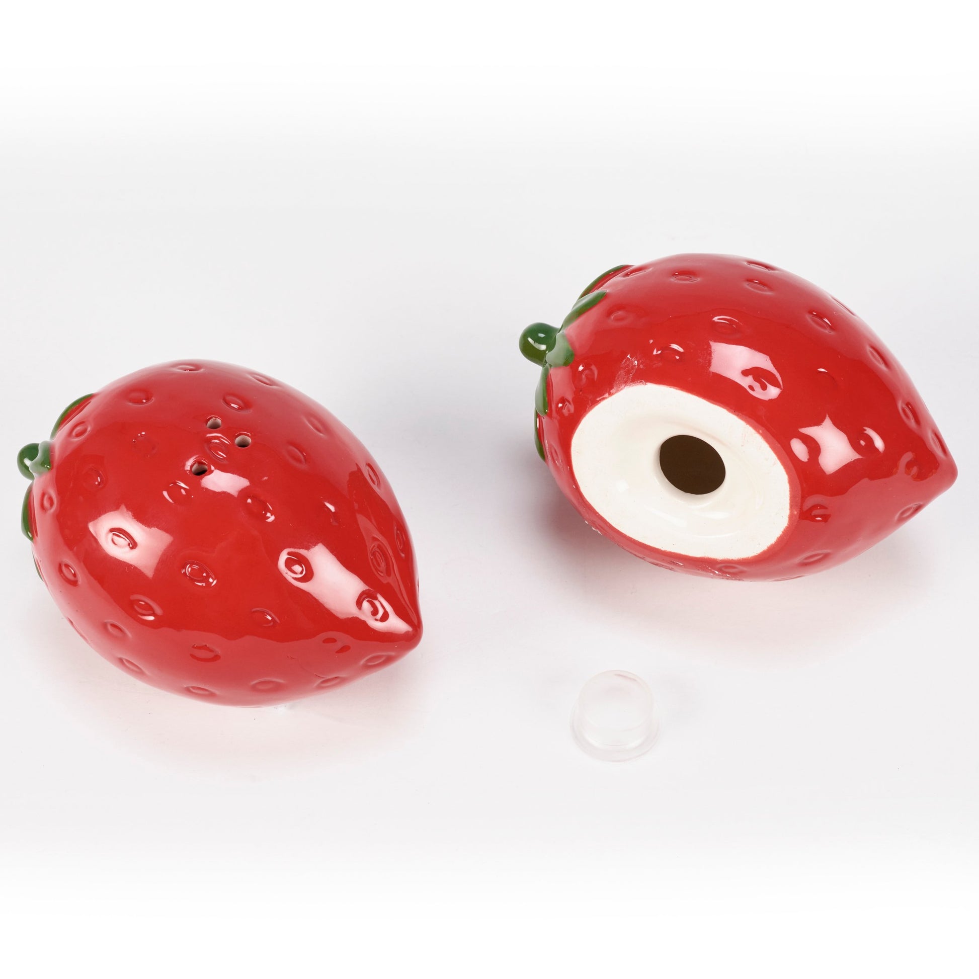 Two strawberry-shaped salt and pepper shakers on a white background
