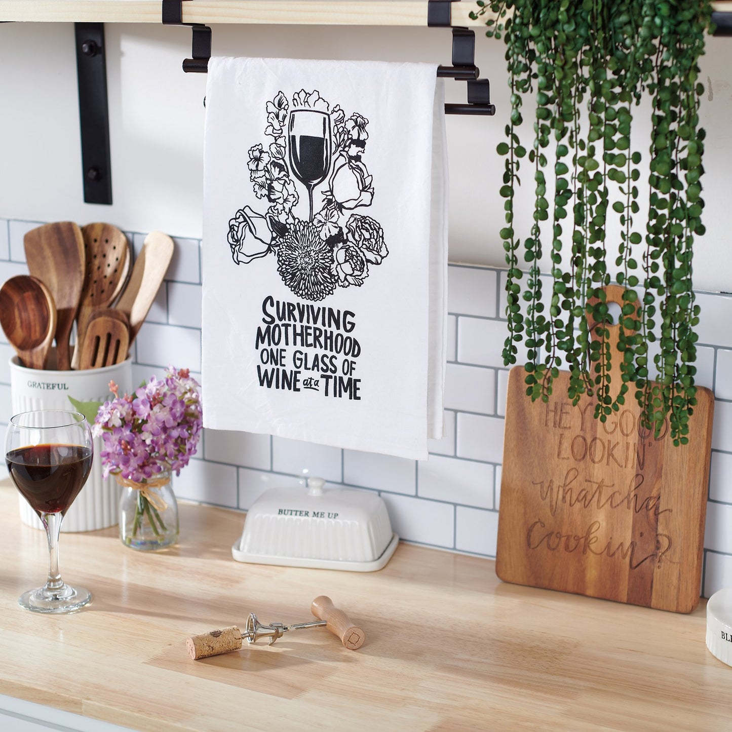 Kitchen counter with wine glass, cutting board, and decorative towel.