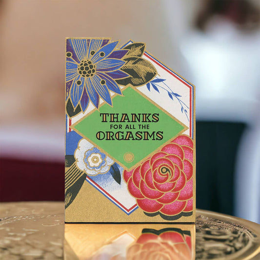 Card with floral design and text 'Thanks for all the orgasms' on a blurred background