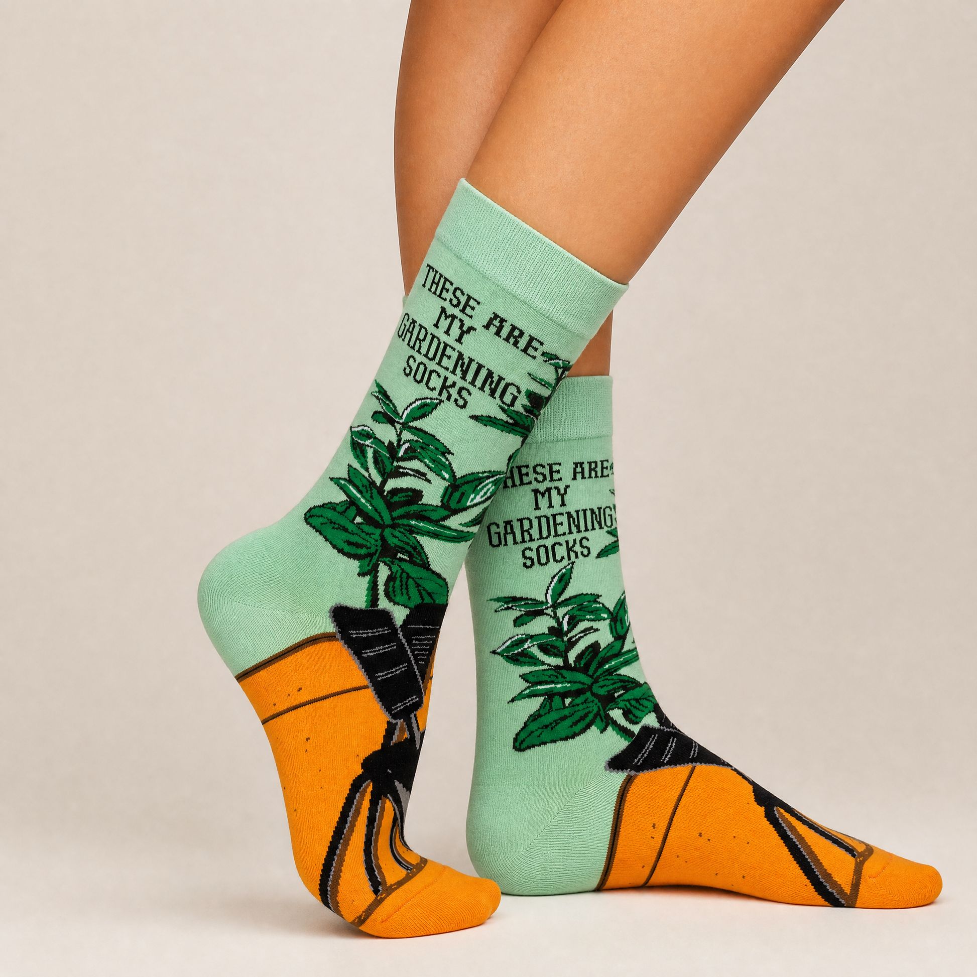 Gardening-themed socks with plant illustrations and text on a neutral background